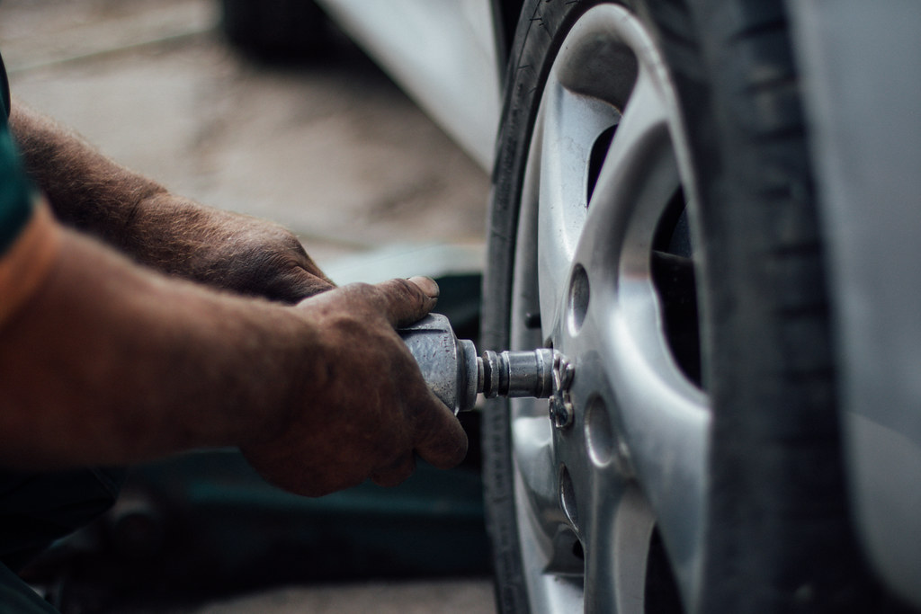 Technician removing a wheel to inspect the brakes